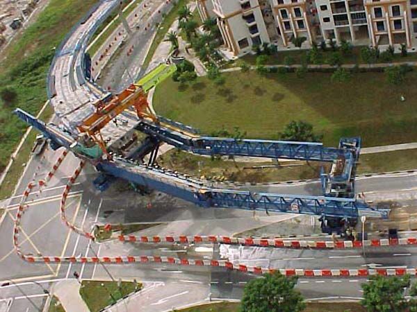 Launching gantry carried on tall piers above a concrete box-girder deck, with the main truss extended over the next span.