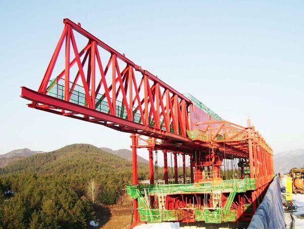 Overhead movable scaffolding system viewed along the deck, showing the main truss, the suspension frames and the formwork carriage below.